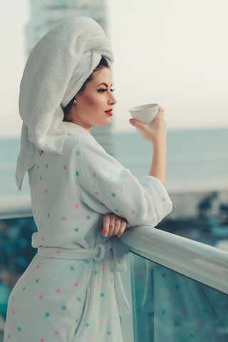 woman in a robe and towel holding coffee